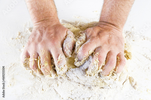 men's hands knead the dough