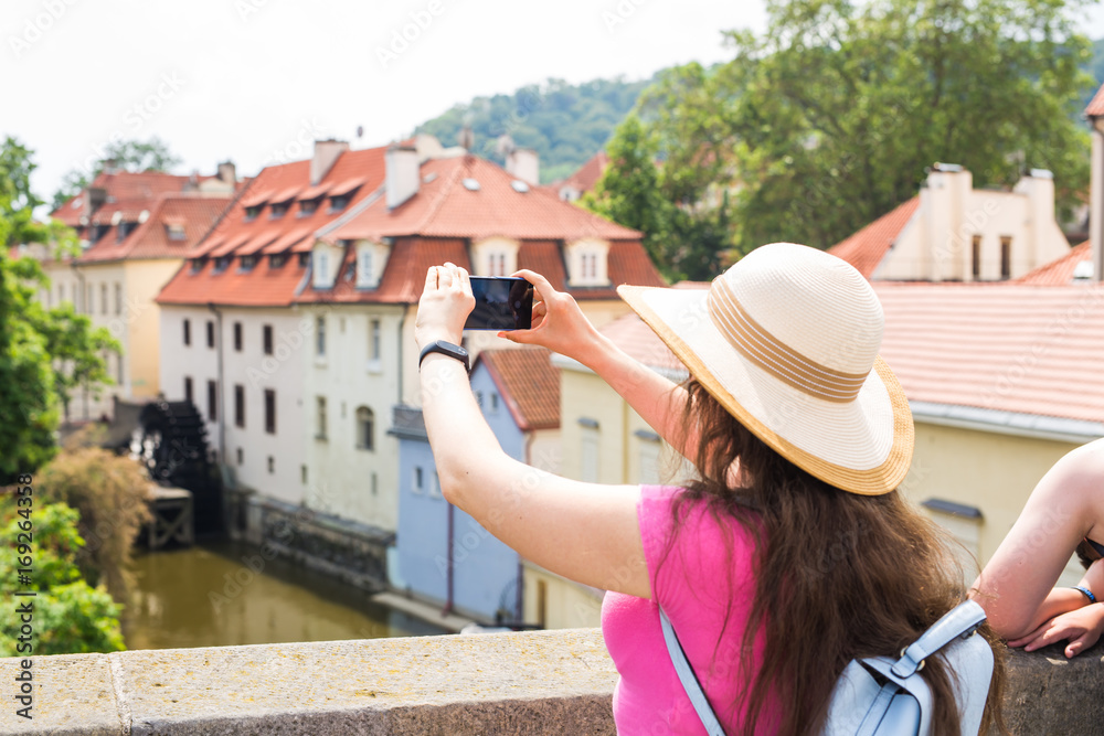 woman taking picture of Old Town in Prague with a smartphone.