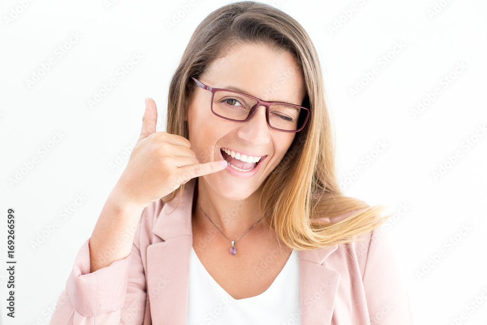 Happy woman showing call gesture and winking