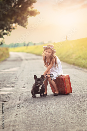 Young girl with suitcase and dog