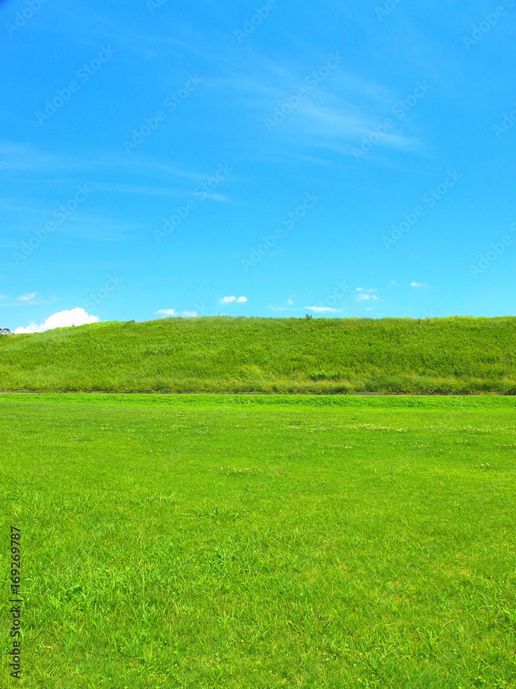 夏の河川敷と土手風景