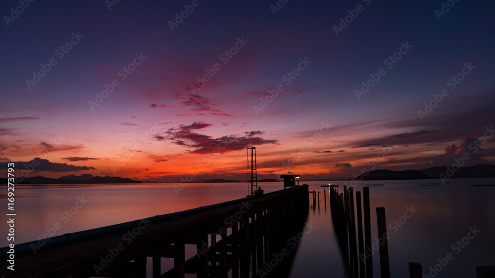 Obraz premium scenery view of old jetty to the sea beautiful sunrise or sunset in phuket thailand.