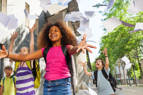 Bild auf Leinwand Girl throw papers in the air for friends to catch