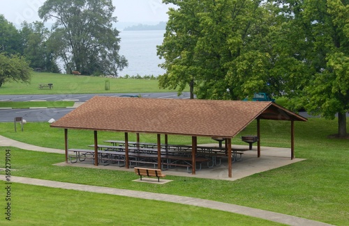 The wood picnic shelter in the park.