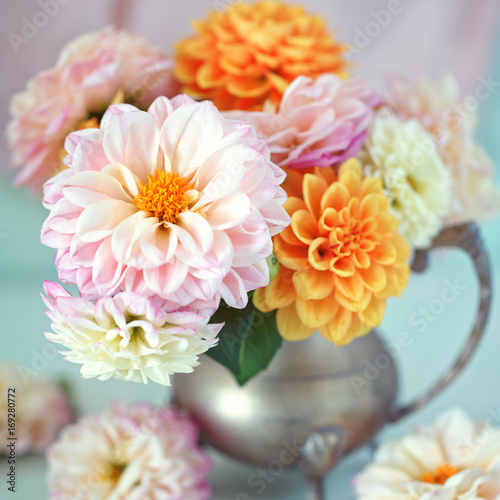 Valokuvatapetti Beautiful bouquet of a yellow and pink dahlias on a light green background