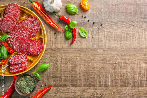 Принти на полотні Plate with sliced different sausages and chili pepper on table