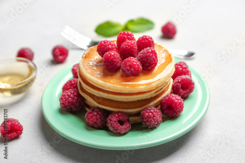 Plate with delicious pancakes on table