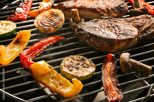 Tasty steaks and vegetables on barbecue grill