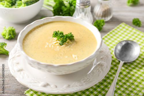 Broccoli cheddar soup in bowl on wooden kitchen table