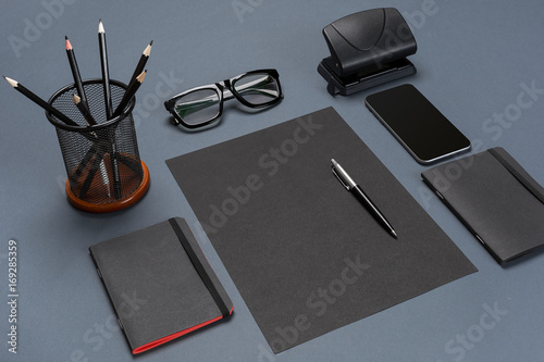 Black office stuff collection flat lay. Top view on set of stationery with smartphone photo