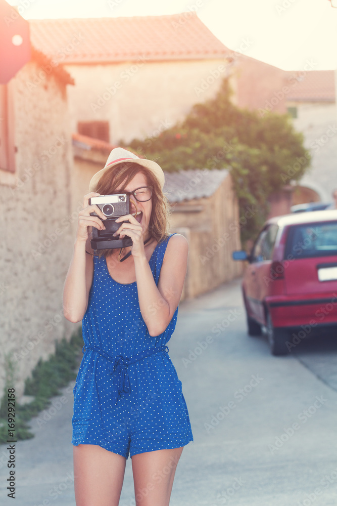 Cute young female holding a retro-styled camera.
