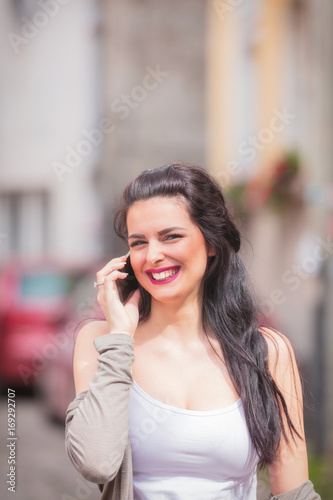 Cute girl using cellphone on the street.