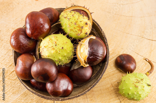 Wild chestnuts with shells in coconut bowl