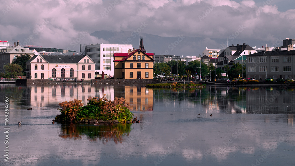 Beautiful reflection of buildings in lake Tjornin. in Reykjavik in summer. Iceland, Europe. Beautiful reflection of buildings in lake Tjornin. in Reykjavik in summer. Iceland, Europe.