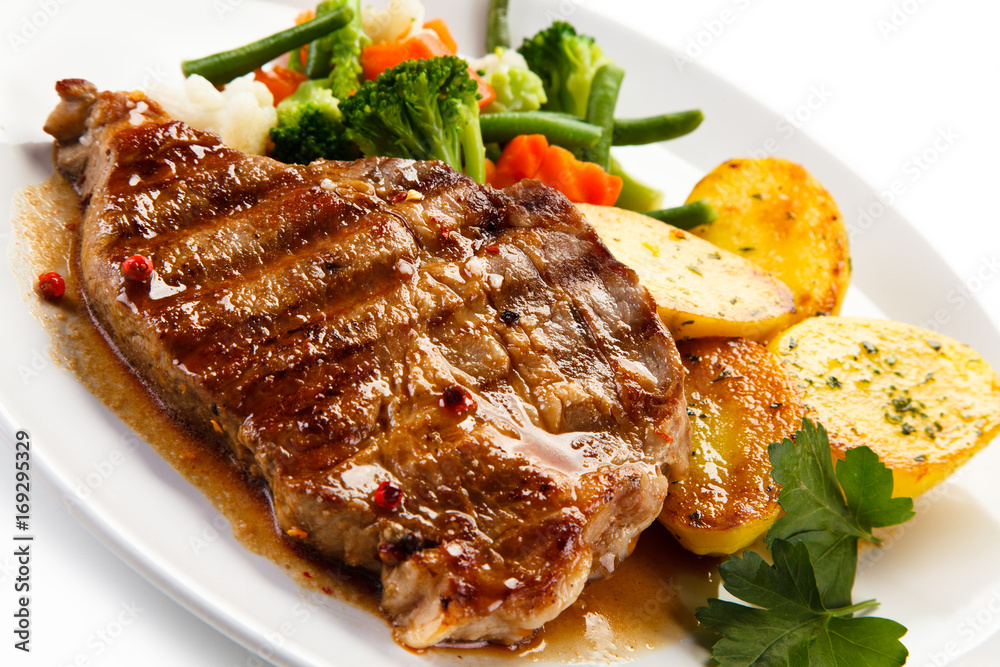 Grilled beefsteak with broccoli and carrot on white background Grilled beefsteak with broccoli and carrot on white background