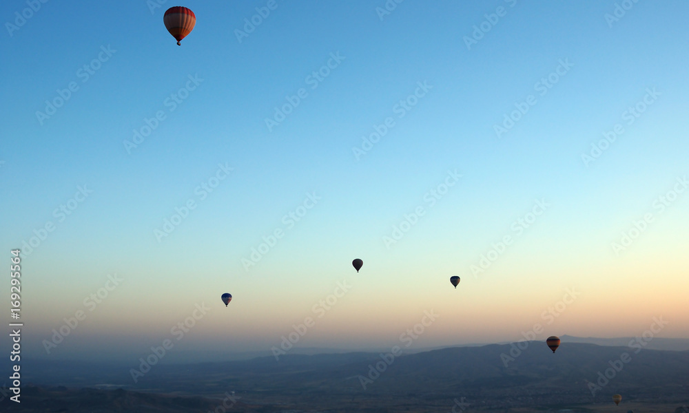 ballooning. A balloon flies in the sky in the rays of the rising sun. A bright sky, a haze, an extinct volcano on the horizon. ballooning. A balloon flies in the sky in the rays of the rising sun. A bright sky, a haze, an extinct volcano on the horizon.