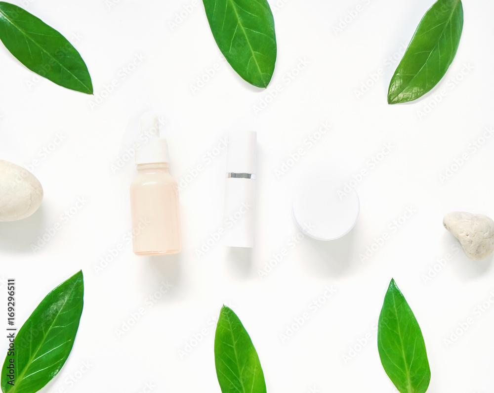 White cream bottle placed, Blank label package for mock up on a green foliage background and flowers. The concept of natural beauty products.