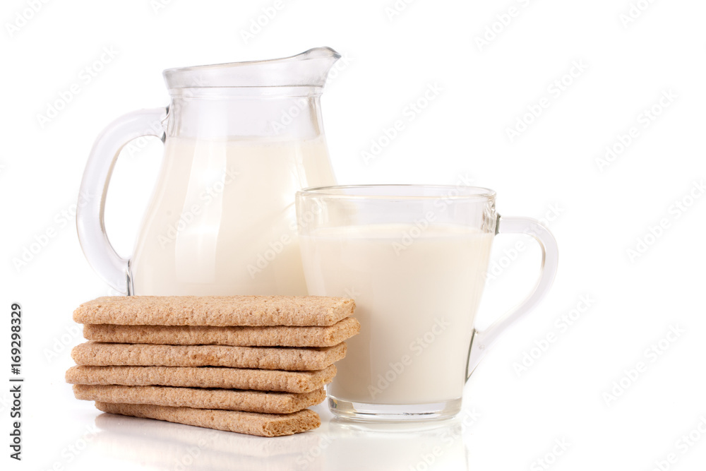 jug and glass of milk with stack of grain crispbreads isolated on white background