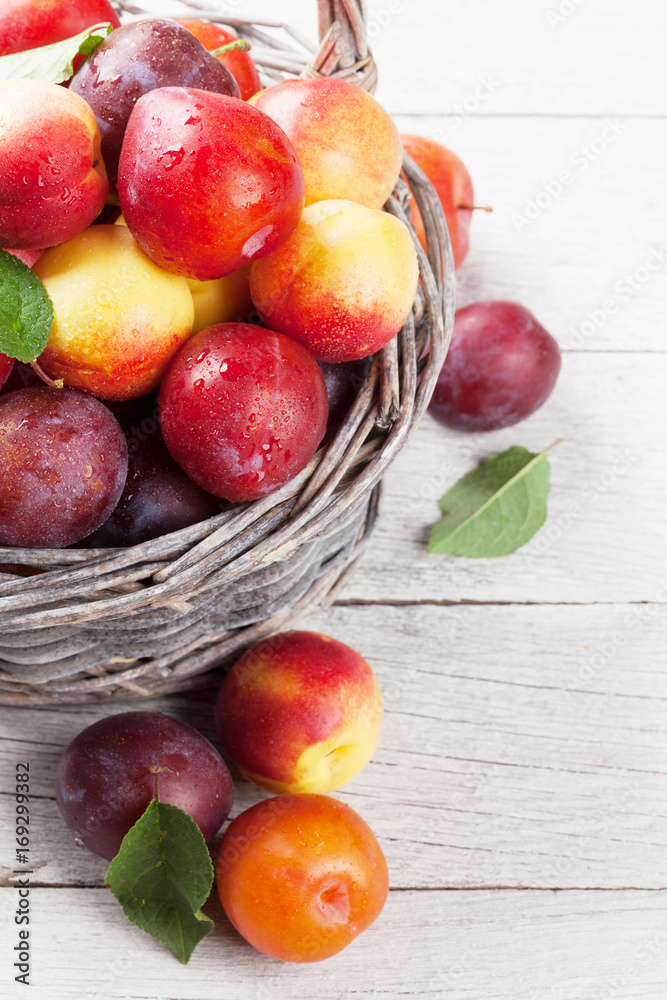 Fresh ripe peaches and plums in basket Fresh ripe peaches and plums in basket
