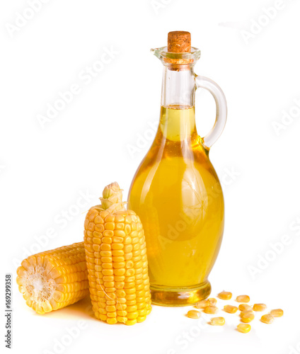 Corn oil in decanter, fresh corn cobs and grains isolated on white background