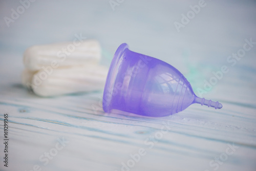 Different types of feminine hygiene products - menstrual cup and tampons photo