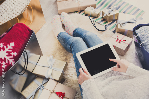 Woman christmas shopping online with tablet, top view