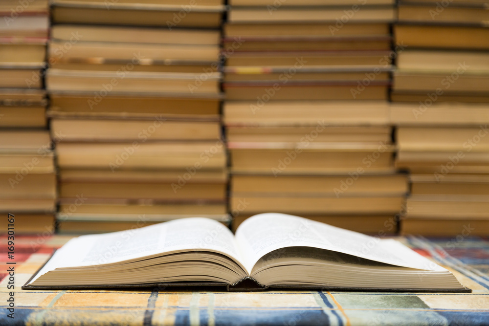 A stack of books with colorful covers. The library or bookstore. Books or textbooks. Education and reading. Open book in the foreground. A stack of books with colorful covers. The library or bookstore. Books or textbooks. Education and reading. Open book in the foreground.