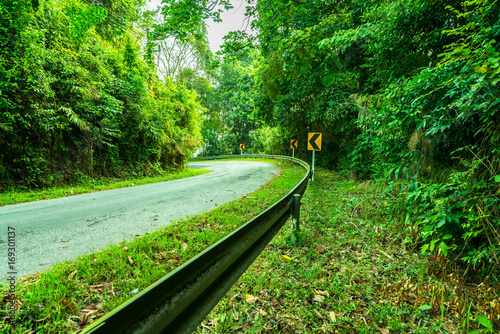 Beautiful asphalt freeway, motorway, highway without traffic through of southern landscape mountains forest during summer on a sunny day. Travel road concept.