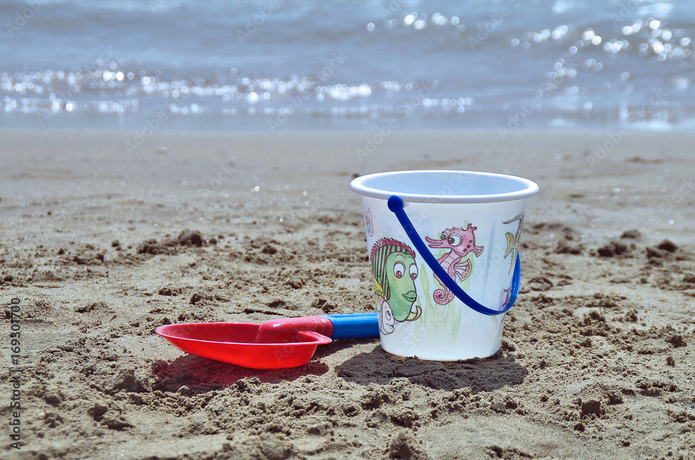 close view of bucket and shovel in a beach playground close view of bucket and shovel in a beach playground