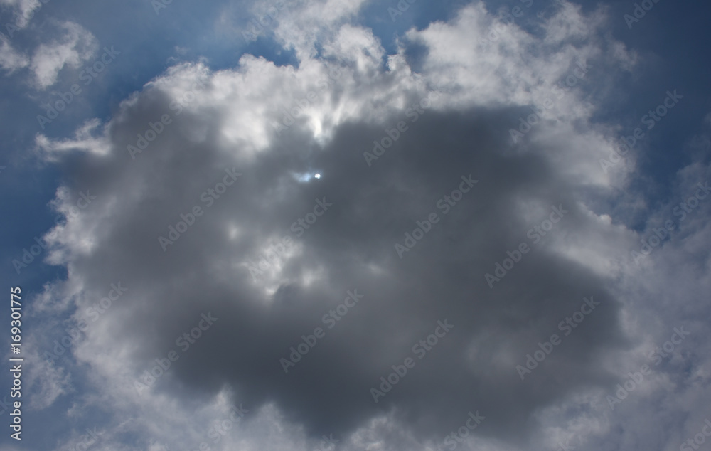 雲から透けて見える太陽と青空「空想・雲のモンスター〔ドラゴンの顔（太陽が目）などが現れはじめたイメージ〕」天国、降臨、神々しい、成功、未来、夢などのイメージ（雲などにキャッチコピースペース）