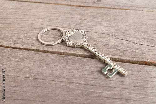 Vintage key. Vintage key with heart shape isolated on the wooden background