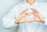 The businessman show heart shape with his hand.