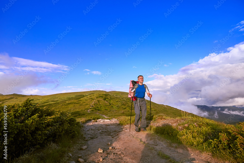 Hiking in the mountains in the summer with a backpack.