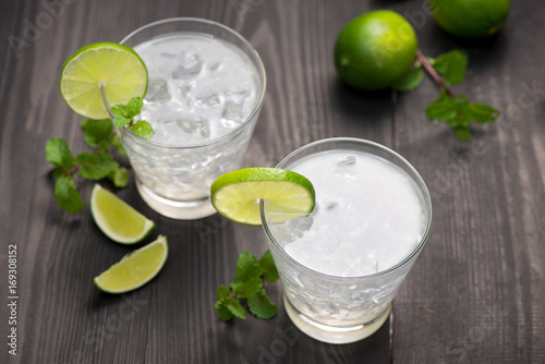 Fresh cocktail with lime, ice and mint on a rustic background. Copy space, top view