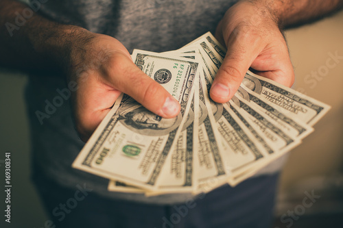 A man holds dollars in his hands