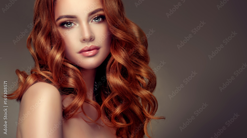 Beautiful model girl with long red curly hair .Red head . Care products ,hair colouring .