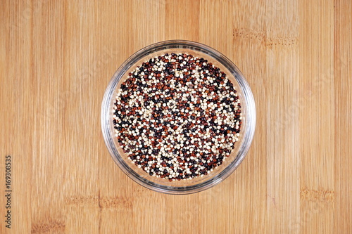 quinoa seeds in glass cup on wooden background