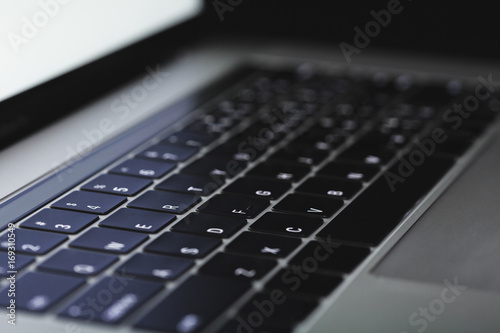 close-up laptop keyboard illuminated on night photo