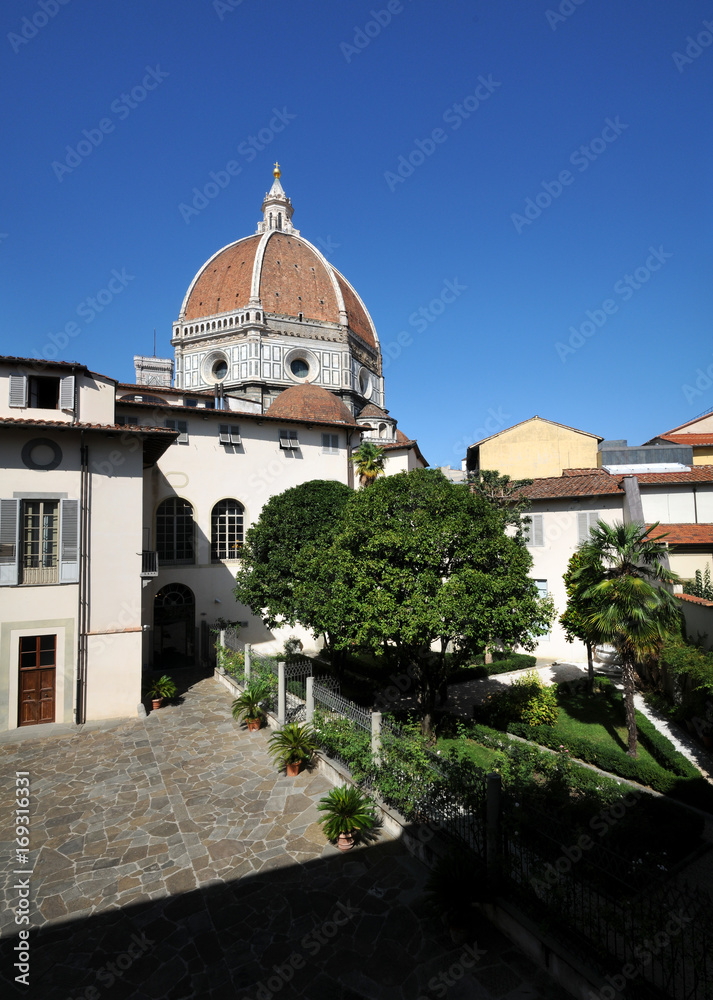 Obraz premium Garden in the centre of Florence and the Cathedral of Santa Maria del Fiore (Duomo di Firenze) on background with beautiful blue sky. Italy.