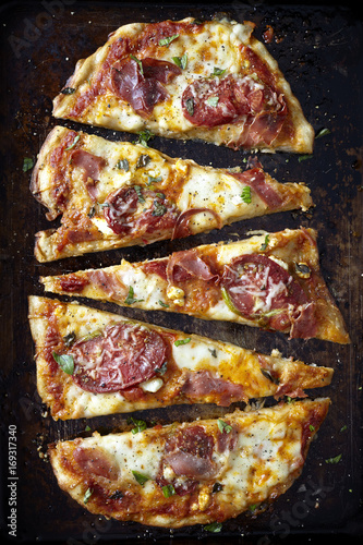 Sliced artisan pizza on a dark background