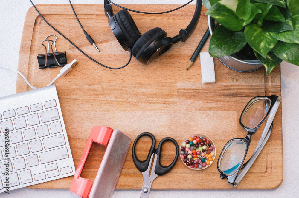 Pencil,Eraser,Paper clip,Keyboard,Headphone,Scissor,Paper puncher,Spec and an ornamental tree on the wooden board Pencil,Eraser,Paper clip,Keyboard,Headphone,Scissor,Paper puncher,Spec and an ornamental tree on the wooden board