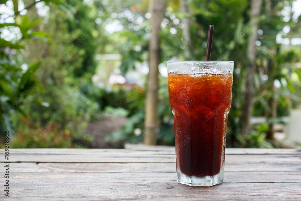 Ice coffee,americano,lemon tea,cola on wood table with green nature background. Copy space. Ice coffee,americano,lemon tea,cola on wood table with green nature background. Copy space.
