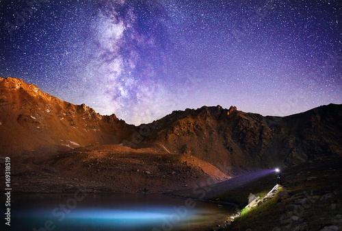 Man with headlight in the mountains at night sky © pikoso.kz