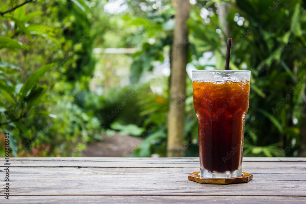 Ice coffee on wood table with green nature background. Copy space. Ice coffee on wood table with green nature background. Copy space.