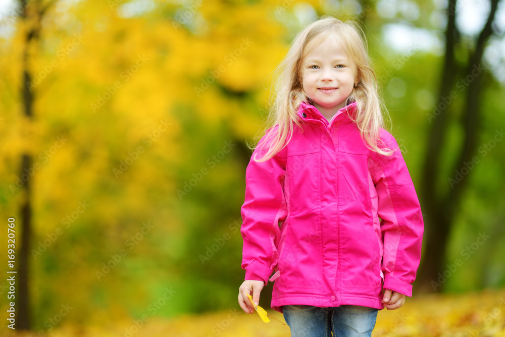 Cute little girl having fun on beautiful autumn day. Happy child playing in autumn park. Kid gathering yellow fall foliage. Cute little girl having fun on beautiful autumn day. Happy child playing in autumn park. Kid gathering yellow fall foliage.