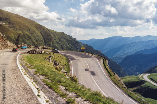 Cars drive on the most famous and dangerous road in Europe is a Transfagarasan road in Carpathian mountains, Romania