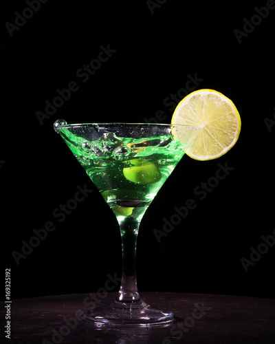 Green cocktail with splash on black background