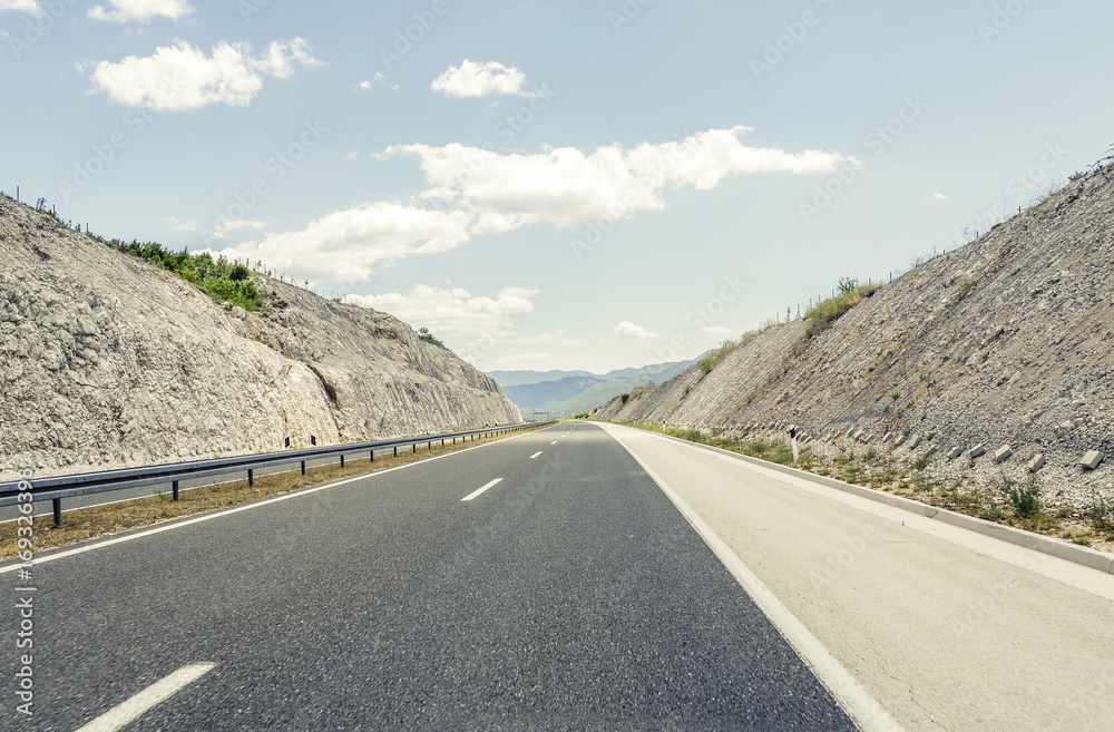 Highway outside the city receding into the highlands.