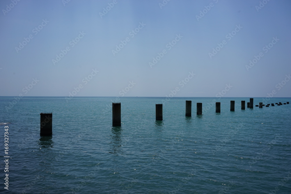 support the old ruined pier in the calm blue sea