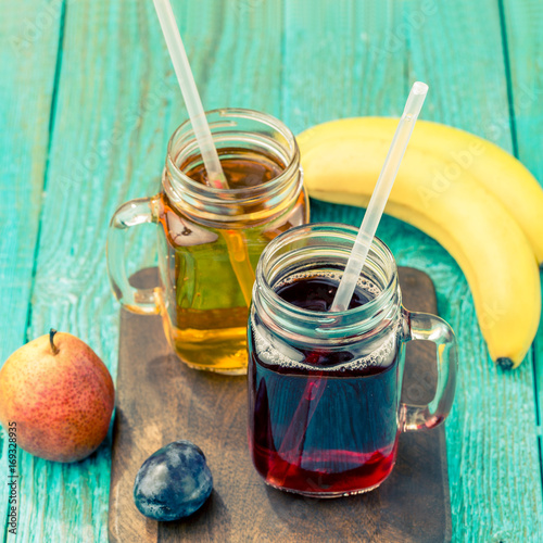 Glasses of juise with fruits on table photo